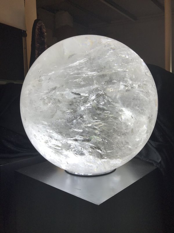 very large, very rare clear rock crystal ball with many ingrown clear green tourmalines