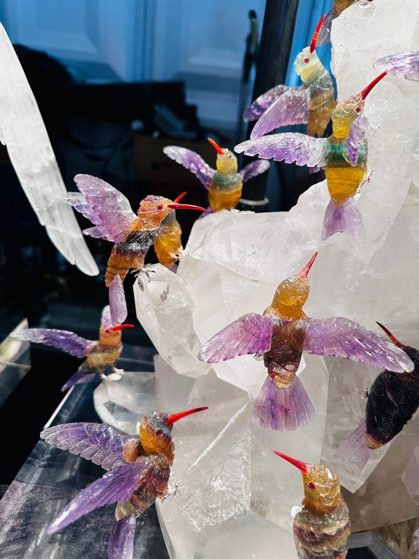 21 fluorite hummingbirds on a large rock crystal