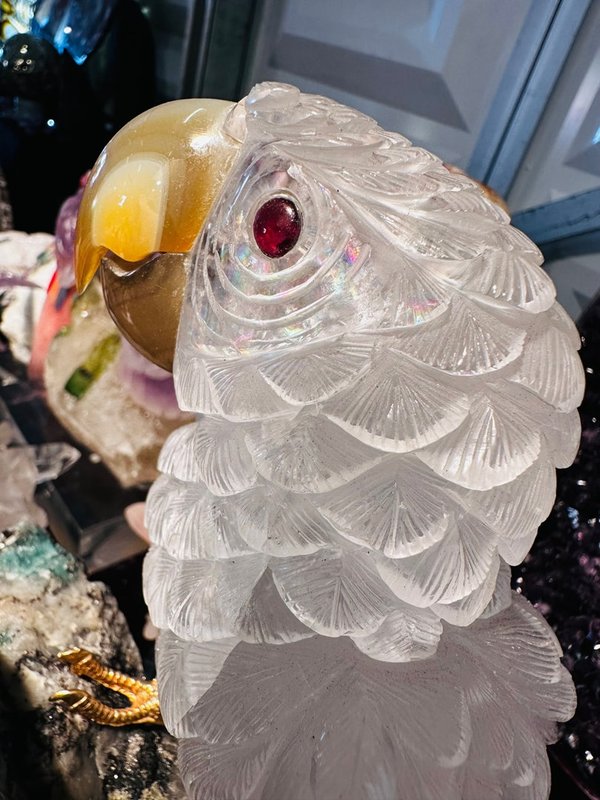 Large pair of parrots made of rock crystal on an emerald natural stone